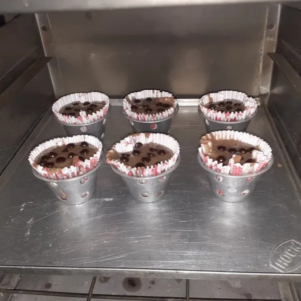 Panaskan oven, panggang adonan. Taburkan chocochips di atas adonan, tusuk adonan dengan lidi untuk melihat kematangan muffin. Jika adonan tidak lengket di lidi, tanda bolu sudah matang.