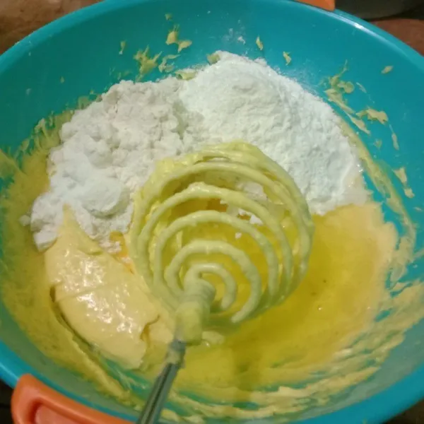 Masukkan perlahan bahan tepung dan telur dalam adonan margarin sambil di kocok rata.