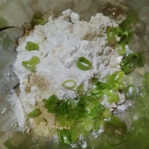 Masukkan tahu, tepung tapioka, garam, kaldu jamur, daun bawang, dan air ke dalam mangkok.