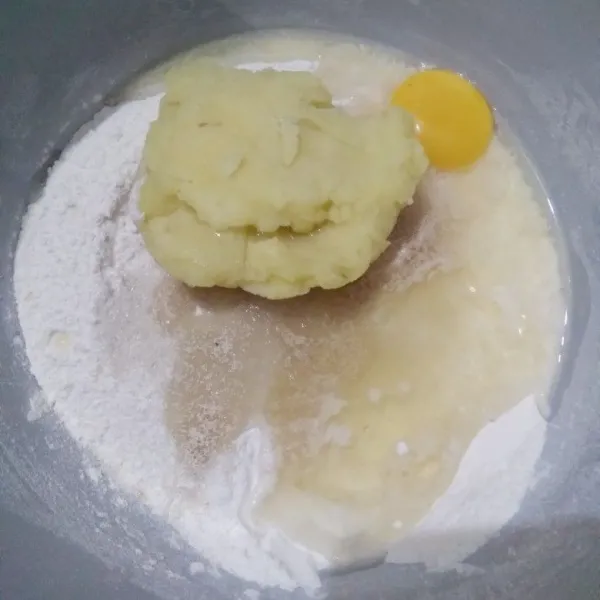 Masukkan tepung terigu, gula pasir, ragi instan, kentang kukus halus, kuning telur, dan air dingin ke dalam mangkok. Mixer hingga tercampur rata.