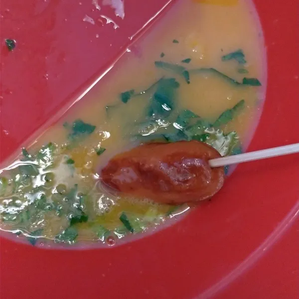 Aduk sosis di telur lalu celupkan di minyak panas yang banyak (deep fry).