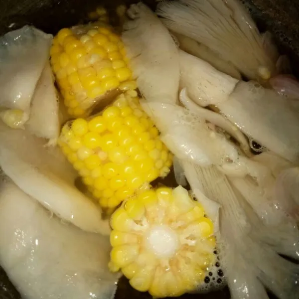 Masukkan jamur ke dalam rebusan jagung dan bumbu.
