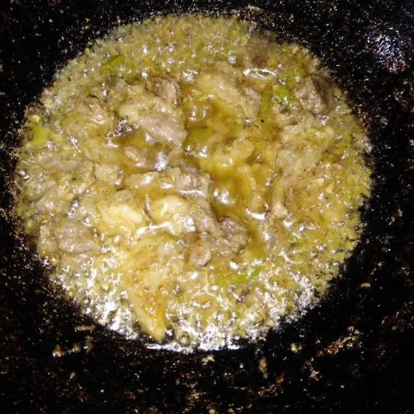 Goreng daging berbumbu dalam minyak panas.