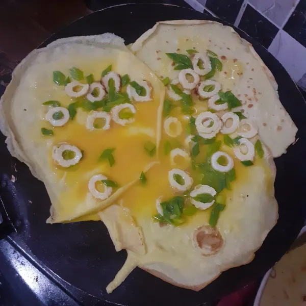 Taruh telur kocok di atas kulit martabak seperti pada foto.