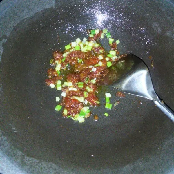 Tumis bumbu halus dan irisan daun bawang hingga harum.