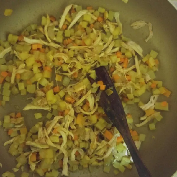 Tumis kentang rebus, wortel rebus, dan ayam rebus. Aduk hingga rata.
