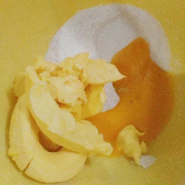 Masukkan gula halus, kuning telur, dan margarin ke dalam wadah.