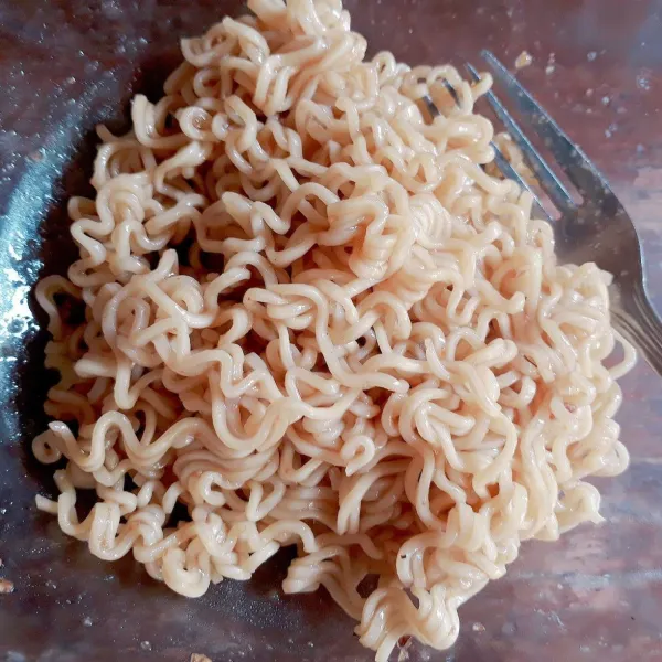 Campur mie dengan bumbu, aduk rata.