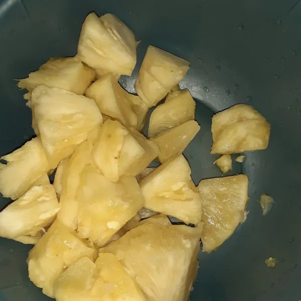 Kupas buah nanas, lumuri dengan garam, cuci bersih, lalu potong-potong.