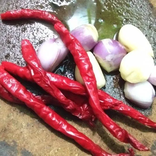 Haluskan bawang merah, bawang putih, dan cabai merah keriting.