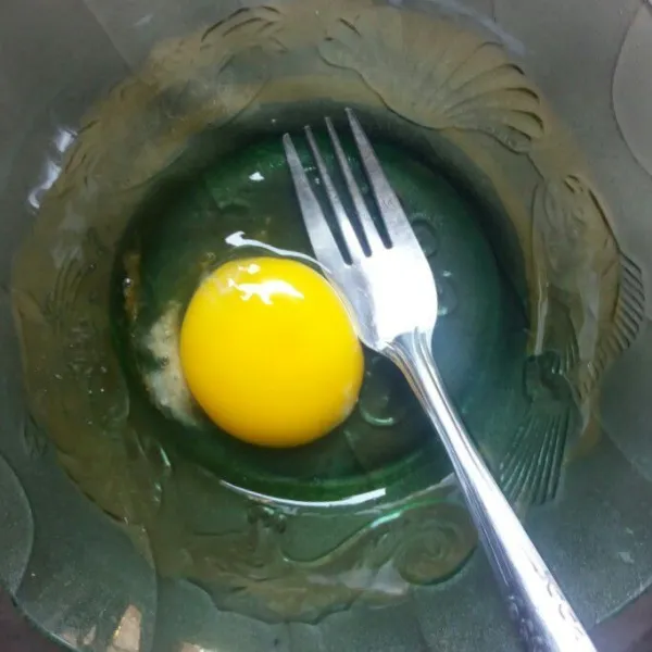 Siapkan mangkuk, pecahkan telur dan tambahkan sedikit garam. Lalu kocok lepas.