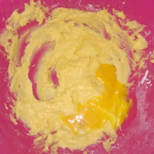 Masukkan kuning telur ke dalam kocokan margarine dan gula halus tadi, mixer lagi hingga rata.