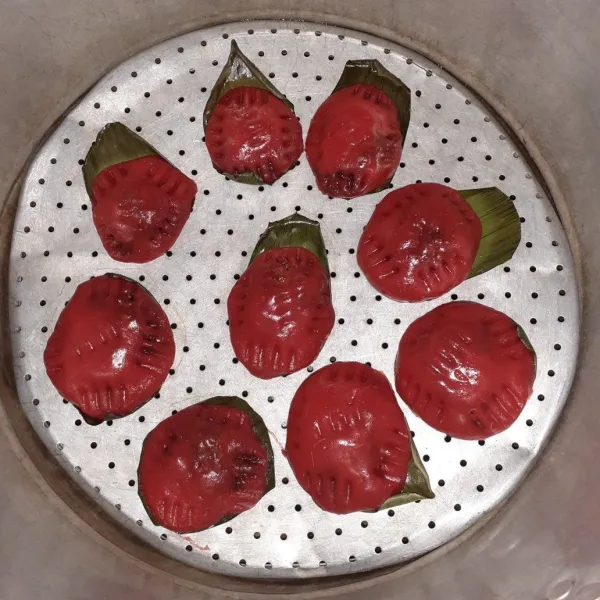 Panaskan panci, kukus kue angku hingga berubah warna.