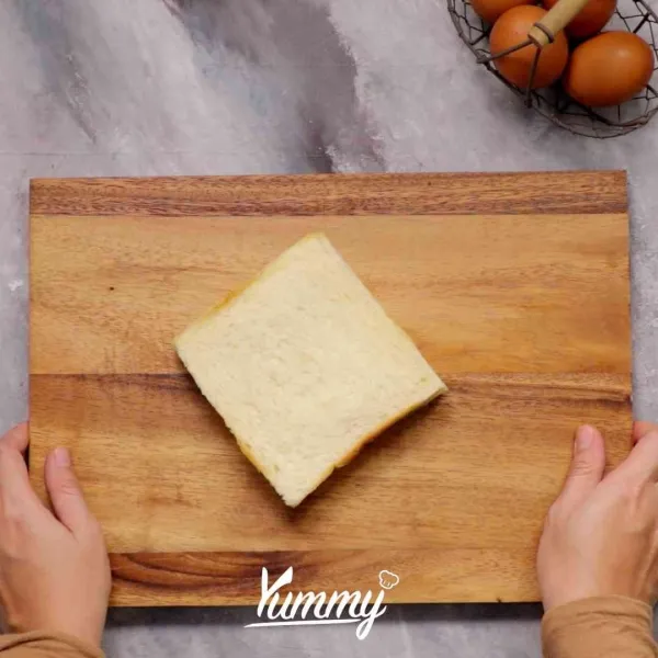 Giling roti tawar hingga pipih, kemudian olesi dengan coklat spread, beri keju slice. Lipat membentuk segitiga dan rapatkan dengan garpu pinggirannya.