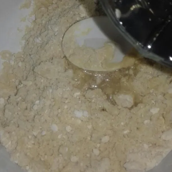 Aduk hingga bergerindil lalu masukkan 2 sdm air es, uleni adonan.