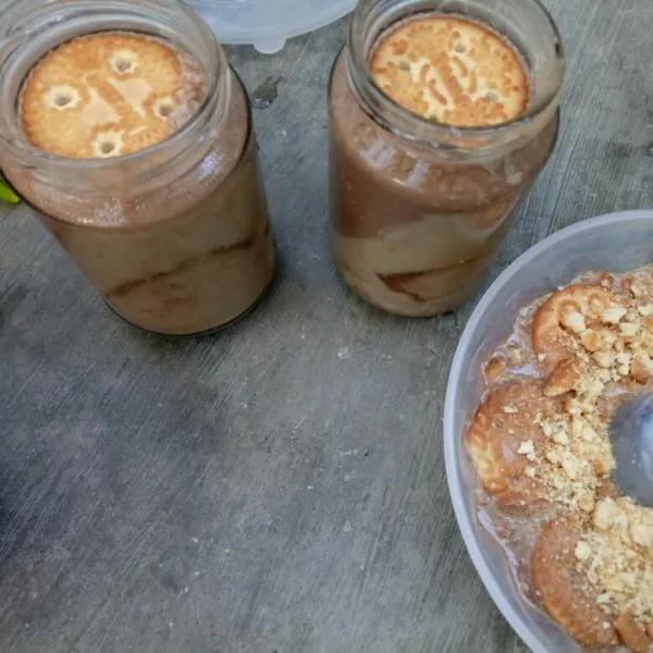 Setelah puding kopi set, tuang puding coklat diatasnya sampai penuh dan beri 1 keping biskuit roma diatasnya, biarkan lagi sampai puding mengeras.