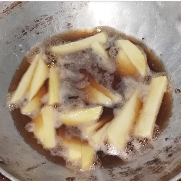 Kupas kentang, cuci bersih, potong panjang-panjang dan goreng sampai matang.