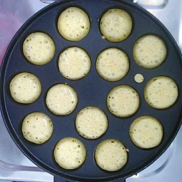 Panaskan cetakan takoyaki, kemudian tuang adonan.