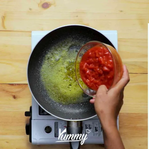 Lelehkan mentega di atas frying pan lalu tambahkan tomat kalengan.