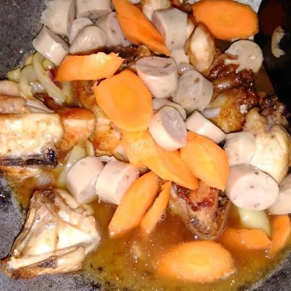 Masukkan sedikit air matang, wortel, dan sosis.