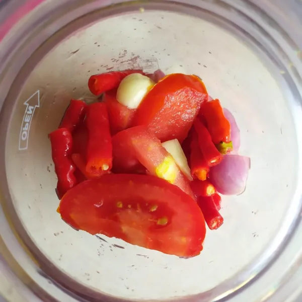 Masukkan tomat, cabe merah keriting, cabe rawit merah, bawang merah, dan bawang putih ke dalam blender. Tambahkan air, lalu haluskan.