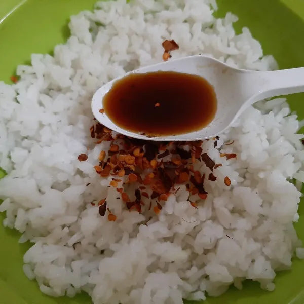 Tambahkan nasi dengan chili flakes dan kecap asin.