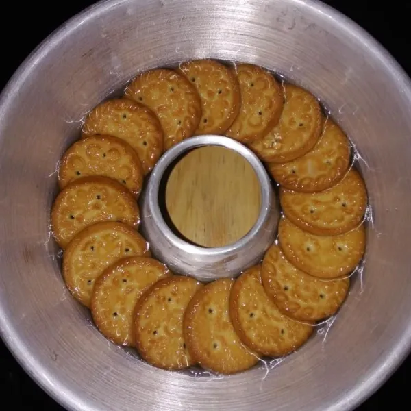 Setelah uap panasnya hilang, tuang lapisan bening ke dalam cetakan yang sudah ditata biskuit, tuang perlahan-lahan saja, sisihkan biarkan set atau setengah beku.