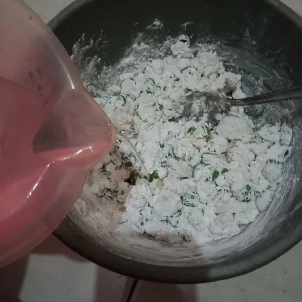 Tambahkan air panas sedikit demi sedikit sampai adonan bisa dibentuk.