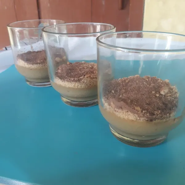 Tambahkan biskuit marie yang sudah diremukkan dan taburi dengan milo. Ulangi step 5 dan 6 sampai terbentuk 3 layer.