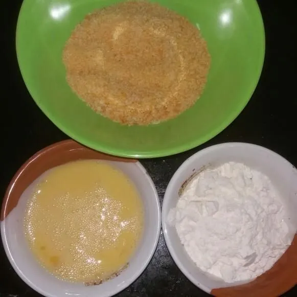 Siapkan telur kocok, terigu, dan juga bread crumbs.