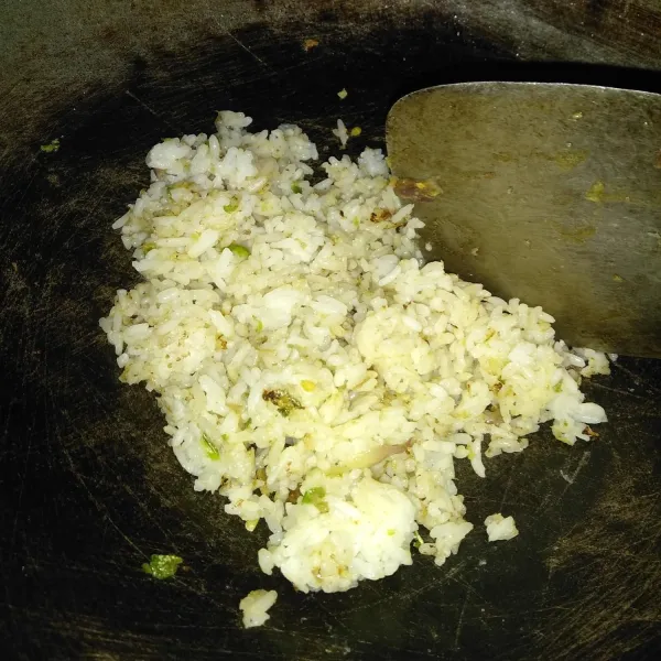 Masukkan nasi dan aduk hingga tercampur rata dengan bumbu dan masukkan penyedap rasa. Aduk kembali hingga rata kemudian koreksi rasa. Masak hingga matang.