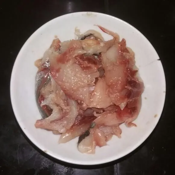 Pisahkan daging ikan dari kepala, tulang, dan kulitnya.