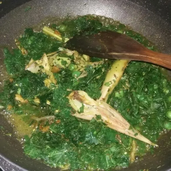 Aduk rata, beri sedikit air lalu masak hingga daun ubi layu dan berubah warna.