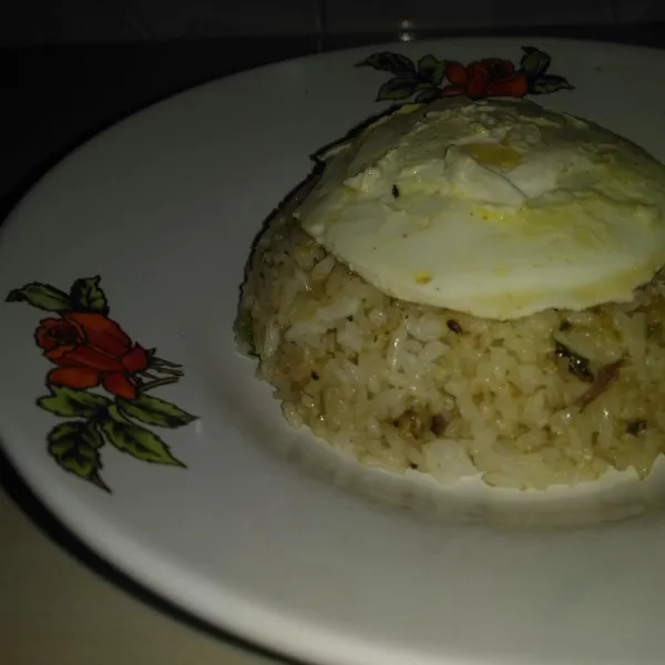 Angkat nasi goreng yang sudah matang, kemudian hidangkan diatas piring bersama dengan telur goreng.