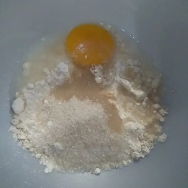 Masukkan tepung terigu, kuning telur, ragi instan, gula pasir, dan air es ke dalam wadah. Aduk hingga tercampur rata.