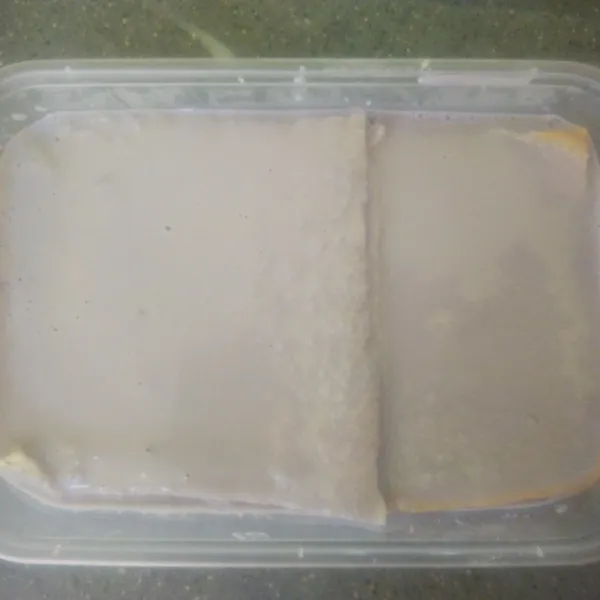 Tutup lagi lapisan vla tadi dengan roti tawar, kemudian timpa lagi dengan vla hingga permukaan roti tawar tertutup merata.