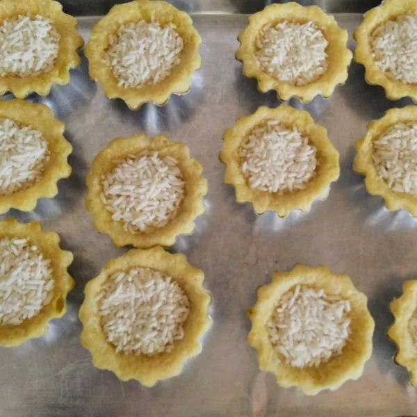 Keluarkan adonan dari kulkas kemudian mulai cetak adonan ke dalam cetakan pie, tusuk-tusuk permukaan kulit pie lalu isi dengan beras. Oven kulit pie hingga matang (lama dan suhu sesuaikan oven masing-masing).