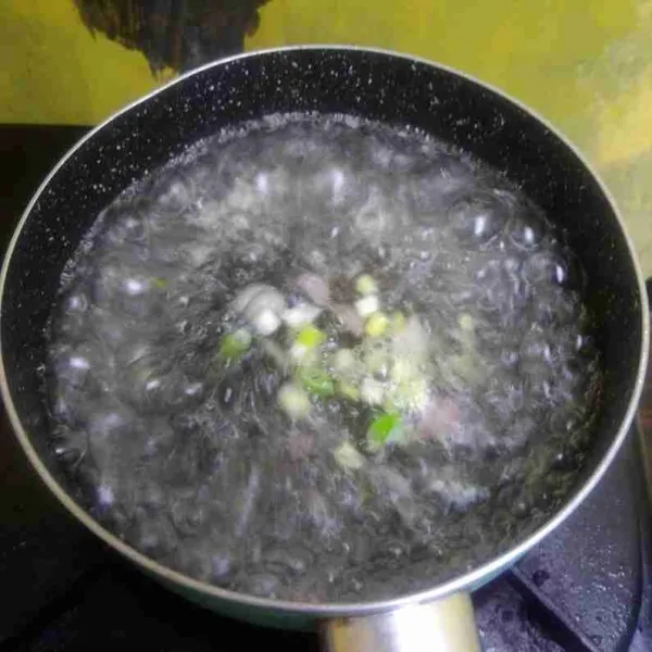 Ketika air sudah mendidih, masukkan bawang merah dan daun bawang. Masak selama 5 menit, lalu tambahkan gula dan garam, koreksi rasa.