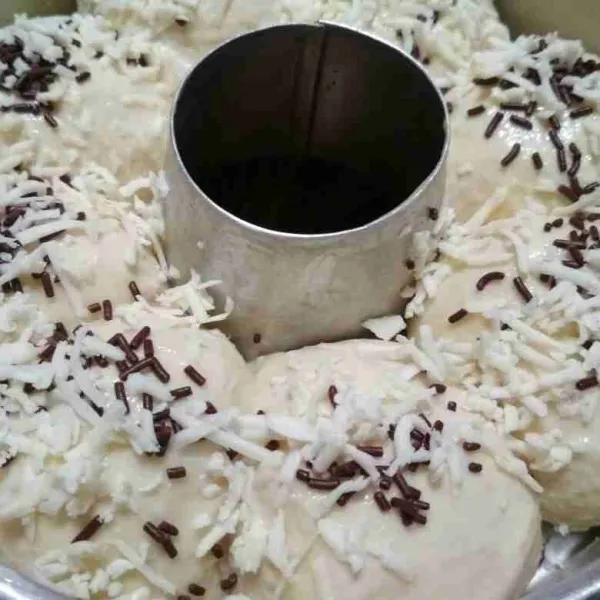 Tata di loyang yang sudah dipoles blueband diamkan 25 menit poles dengan susu cair taburi topping.