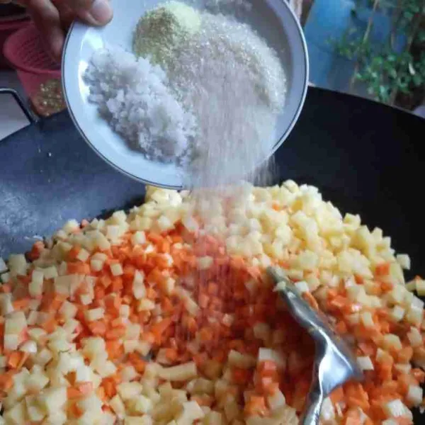 Tumis bawang merah dan bawang putih sampai harum, masukkan kentang dan wortel. Beri garam, gula panir, kaldu bubuk, merica bubuk, dan air.