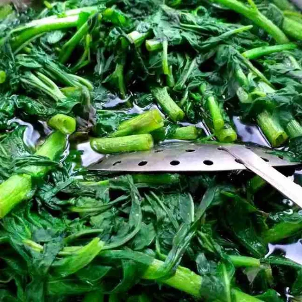 Potong bagian batang yang keras lalu rebus sayur sampai matang.
