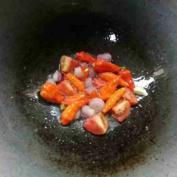 Goreng cabe rawit, bawang putih, bawang merah, dan tomat sampai layu.