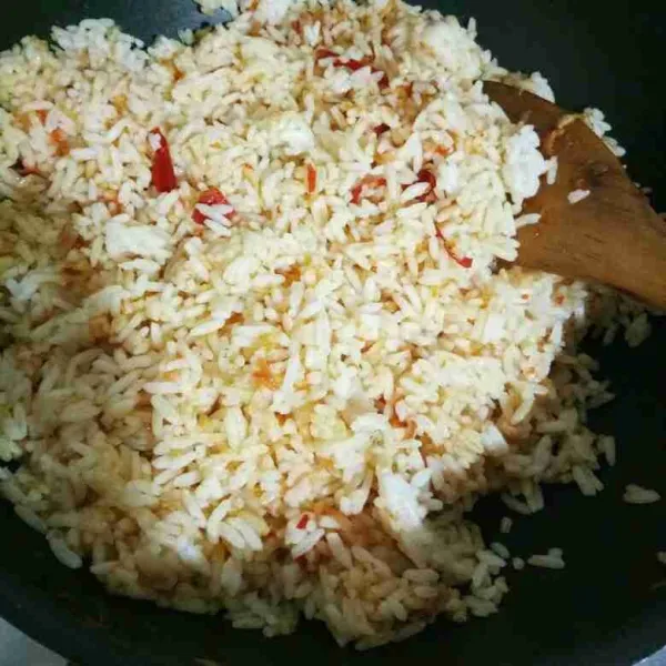 Masukkan nasi, aduk rata hingga nasi terbalur bumbu.
