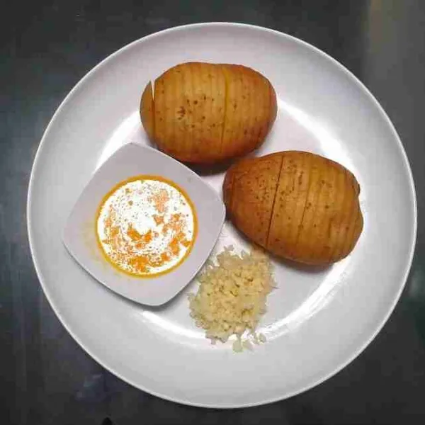 Cuci bersih kentang dengan kulitnya. Iris cukup tipis, tetapi jangan sampai putus. Cincang bawang putih dan lelehkan salted butter.