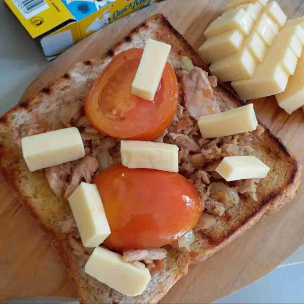 Ambil 1 lembar roti gandum, beri tumisan tuna secukupnya, beri irisan tomat (tomat boleh dipanggang bila suka), beri keju quick melt lalu tutup kembali dengan selembar roti.