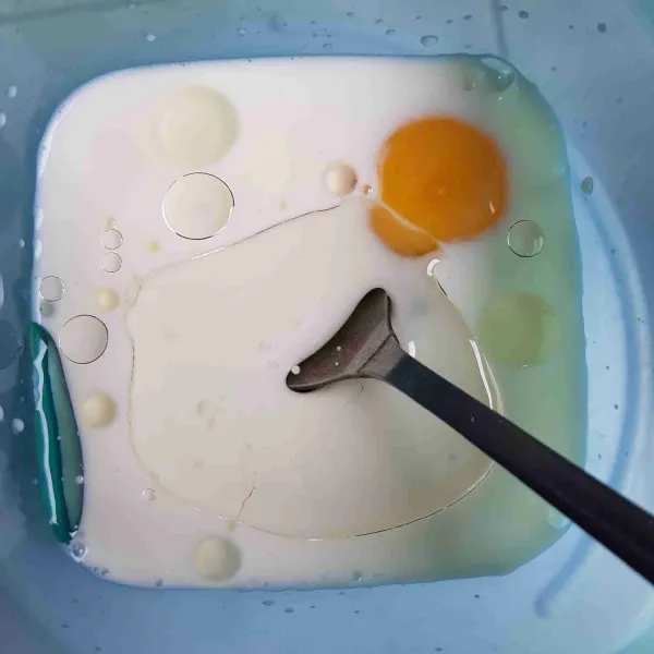 Siapkan wadah, masukkan susu cair, telur dan minyak kelapa. Aduk hingga rata, sisihkan.