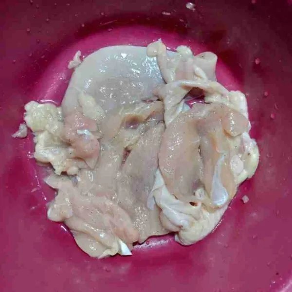 Rendam ayam dengan bawang putih, garam, dan lada bubuk. Diamkan selama 10 menit.
