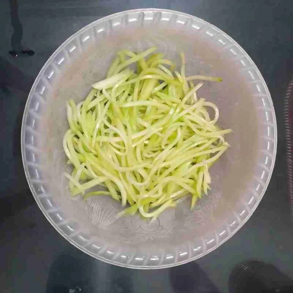 Kupas labu dan iris memanjang. Jangan terlalu tebal atau terlalu tipis. Remas dengan sedikit garam agar irisan labu lemas dan tidak bergetah. Biarkan beberapa saat, kemudian bilas dan tiriskan.