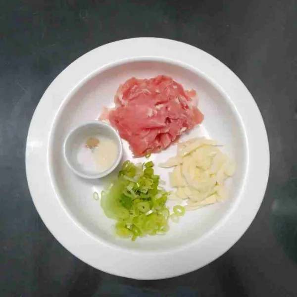 Iris tipis daging kemudian rajang bawang putih dan bawang prei.