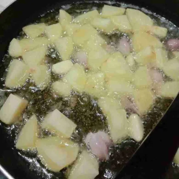 Goreng kentang dan bawang merah, bawang putih hingga matang , angkat dan tiriskan.